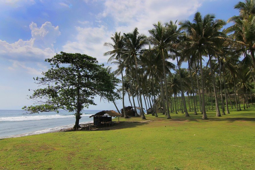 lapangan rumput di dekat pantai sering digunakan masyarakat untuk bermain bola